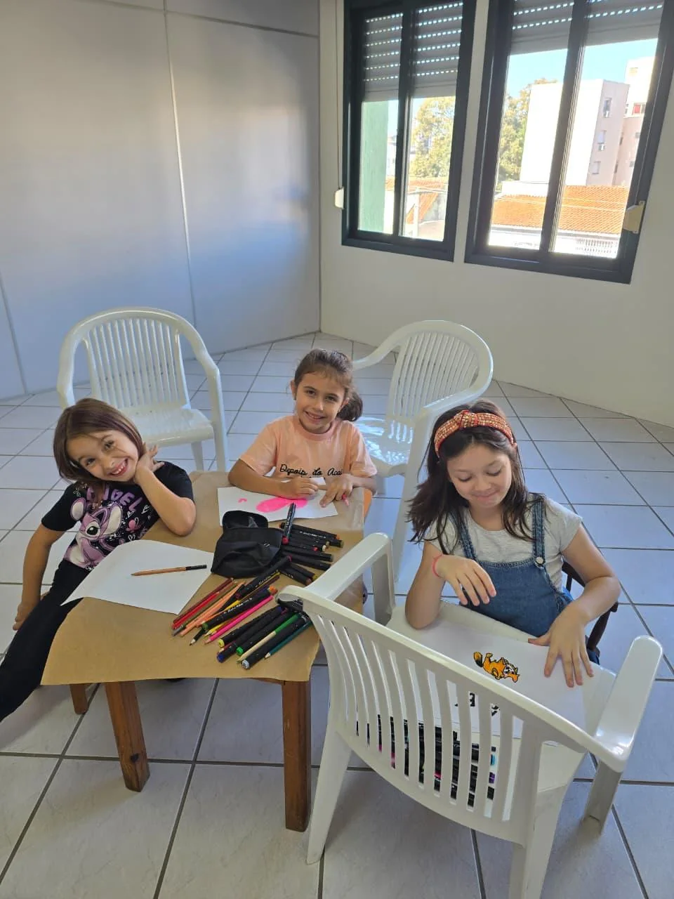 Crianças desenhando à mesa durante uma atividade